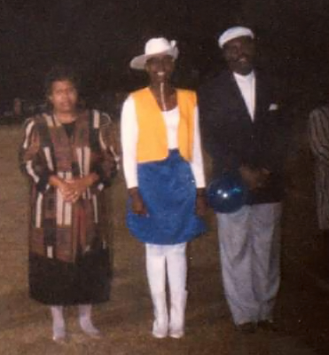 Trenette Goings with her parents as she poses in her high school band uniform