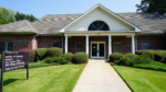 Red-brick building with white columns and a sign reading “Institute for Behavioral Research, Center for Family Research” at the entrance, surrounded by trimmed bushes and green lawn.