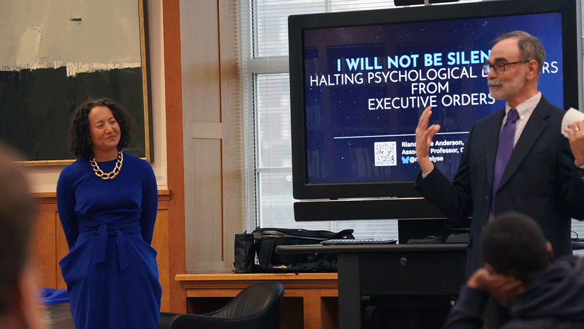 Man and woman in front of a projection screen.